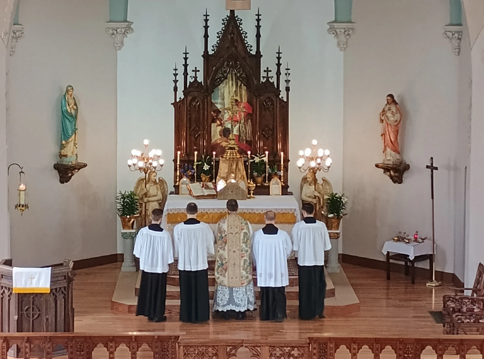 Fr. Timothy Scott Hoopes facing the altar with servers at St. Charles in 2025.