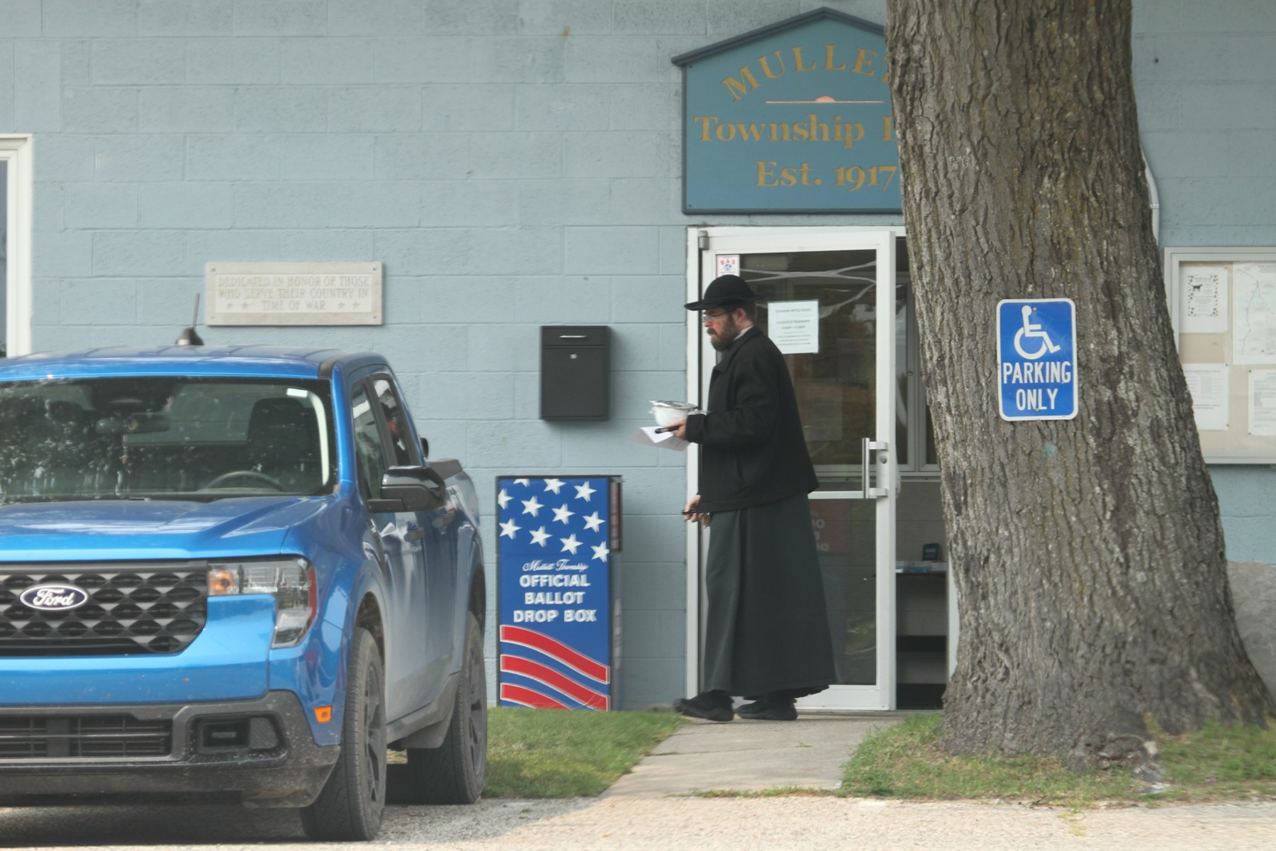 Hoopes in clerical clothing standing outside the former fire station in Topinabee.